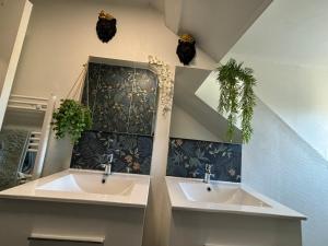a bathroom with two sinks and plants on the wall at Jungle Cosy in Louviers +42 photos
