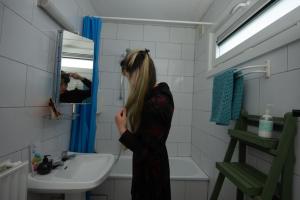 a woman standing in a bathroom looking in the mirror at La Pierraille in Froid-Chapelle