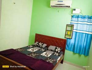 a bedroom with a bed with pillows on it at JAS HOMESTAY MADURAi in Tirupparangunram