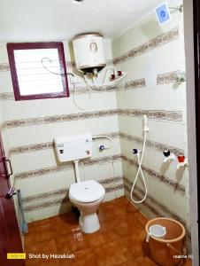 a small bathroom with a toilet and a window at JAS HOMESTAY MADURAi in Tirupparangunram