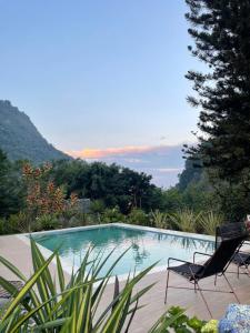 卡利ALMAH GLAMPING的一个带两把椅子的游泳池和一个山