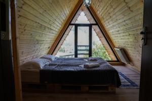 un letto in una camera con una grande finestra di UnderHill Kazbegi a Kazbegi