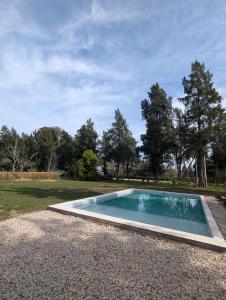 a swimming pool in the middle of a yard at Casa para 6 en Estancia Las Malvinas in Brandsen