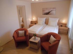 a hotel room with a bed and two chairs at Villa Vogelsang VO, Schwimmbad, Sauna in Sierksdorf +29 photos