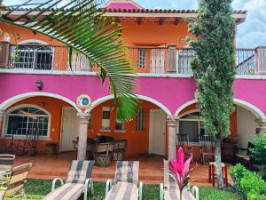 a colorful house with chairs and a palm tree at Hotel Casa Corita in Jala
