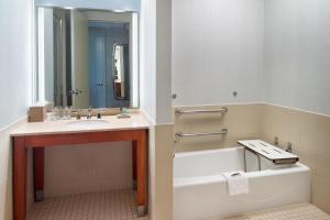 a bathroom with a tub and a sink and a mirror at The Westin Memphis Beale Street in Memphis
