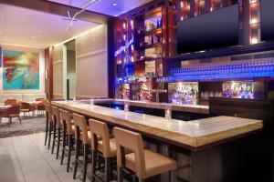 a bar with chairs and a flat screen tv at The Westin Memphis Beale Street in Memphis