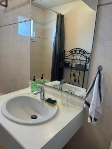 フレジュスにあるAppartement moderne à Fréjus, 60 m², piscine partagéeの白い洗面台と鏡のあるバスルーム