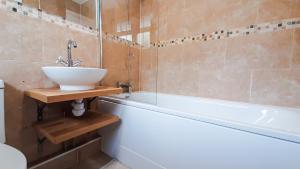 a bathroom with a sink and a bath tub at Stunning 2 bedrooms apartment in London +5 photos