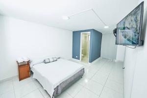 a bedroom with a bed and a flat screen tv at Acogedora casa cerca al estadio in Robledo