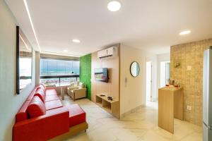 a living room with a red couch and a table at Mirante de porto 108 in Porto De Galinhas