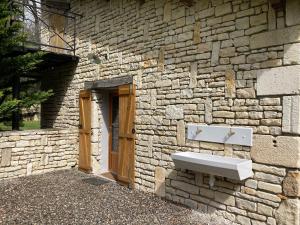 a stone building with a sink on the side of it at POD Nature 2 in Chazelles