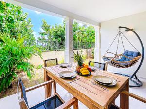 a dining room with a swing and a table at Serenity beachfront studio in Orient Bay in Orient Bay
