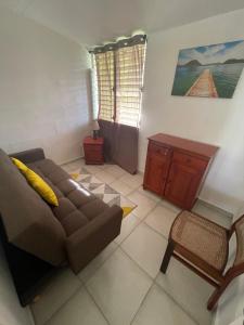 a living room with a couch and a table at Maison proche aéroport Abymes in Belle-Plaine