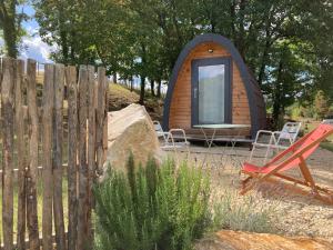 a small cabin with a fence and a red bench at POD Nature 2 in Chazelles