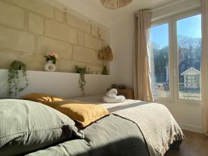 a bed in a bedroom with a large window at Duplex cinéma - centre historique Tours in Tours