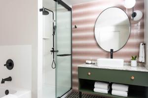 a bathroom with a sink and a mirror at Hotel Indigo Saint Louis Central West End by IHG in Saint Louis +16 photos