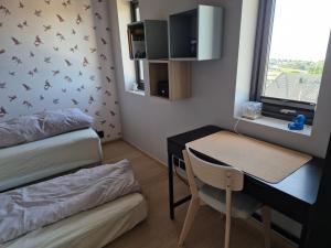 a small room with a desk and a table with a chair at New and trendy home with fjord view in Ranheim