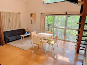 a living room with a table and chairs and a couch at Snowood Chalet Hakuba in Hakuba