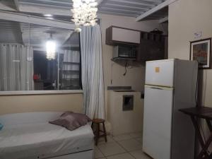a small kitchen with a white refrigerator and a window at Apartamento central 78 com excelente vista in Ponta Grossa