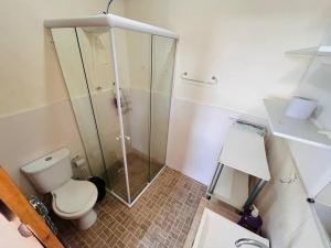 a bathroom with a toilet and a glass shower at Apartamento central 78 com excelente vista in Ponta Grossa +35 photos