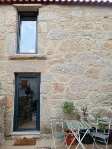 a stone building with a bench and a window at Casa da Fraga in Viana do Castelo