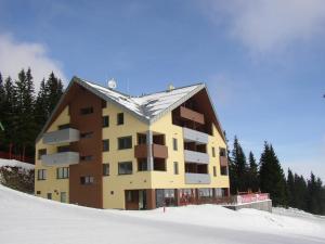 um grande edifício no topo de uma encosta coberta de neve em Apartmány Margo Sun em Martinske Hole