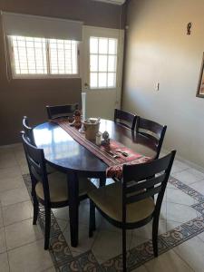 a dining room table and chairs in a room with a table at Departamento en Guaymallén in Guaymallen