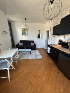 a living room with a couch and a table at Grey Cosy in Louviers +16 photos