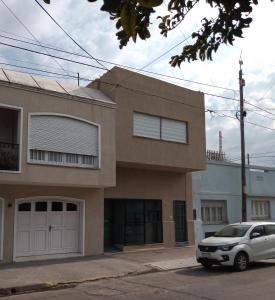 a white car parked in front of a house at Atenea Departamentos Temporarios in Villa María