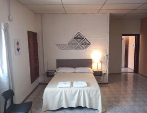 a bedroom with a bed with two towels on it at Atenea Departamentos Temporarios in Villa María