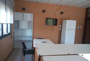 an office with a white table and a refrigerator at Atenea Departamentos Temporarios in Villa María