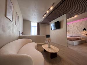 a living room with a couch and a table at Harmony Room Suite avec Balnéo in Angers