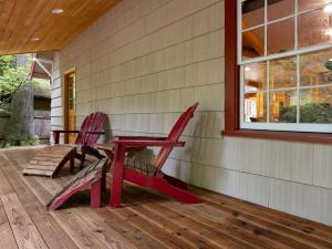 two red chairs and a picnic table on a porch at Whispering Pines - Cabin w hot tub in Rhododendron