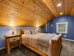 a bedroom with a bed and a wooden ceiling at Whispering Pines - Cabin w hot tub in Rhododendron