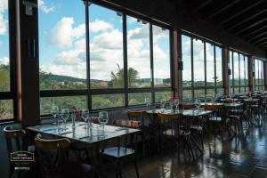 a dining room with tables and chairs and windows at Pirenópolis Quinta Santa Bárbara - Apto 2q para 06 pessoas - Térreo in Pirenópolis +15 photos