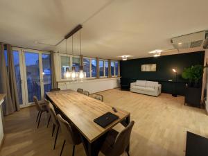 Munich Large Apartment 150 qm in top located with 4 Bedrooms 1 to 15 guests في ميونخ: غرفة معيشة كبيرة مع طاولة وكراسي