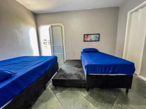 a bedroom with two beds and a window at 04 · No Fresquinho do Ar in Guarujá