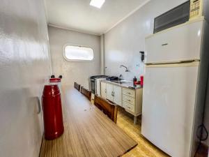 a kitchen with a red fire hydrant and a refrigerator at 04 · No Fresquinho do Ar in Guarujá