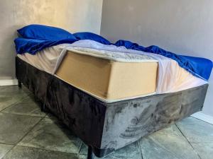 a bed sitting in a corner of a room at 04 · No Fresquinho do Ar in Guarujá