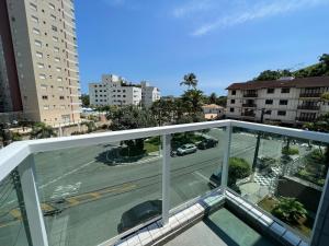 a view of a city street from a balcony at 04 · No Fresquinho do Ar in Guarujá