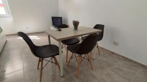 a table with four chairs and a computer in a room at La Dolce Vita in Fiumicino +9 photos