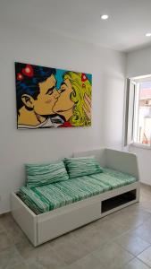a bedroom with a bed with a painting on the wall at La Dolce Vita in Fiumicino