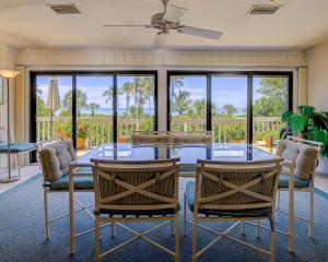 a dining room with a glass table and chairs at Set Point Home in Ybel