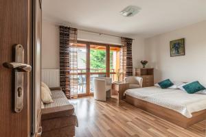 Un dormitorio con una cama y una sala de estar. en Klemensówka, en Krynica-Zdrój