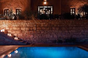 ein Pool in einem Haus bei Nacht mit Lichtern in der Unterkunft Riad Bouchedor in Ouarzazate