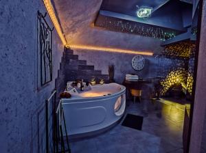 een badkamer met een wit bad in een kamer met een trap bij Neon Jacuzzi Centrum Rynek in Kielce
