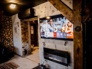 een woonkamer met een televisie aan de muur bij Neon Jacuzzi Centrum Rynek in Kielce