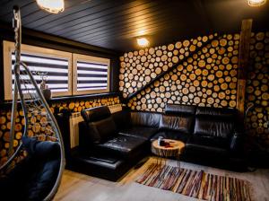 een woonkamer met een zwarte leren bank en een tafel bij Neon Jacuzzi Centrum Rynek in Kielce