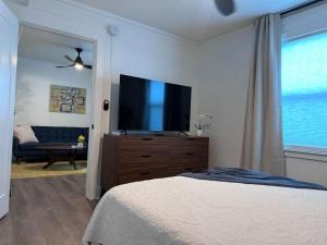 a bedroom with a bed and a flat screen tv at Modern Unit 313 at The George in Klamath Falls